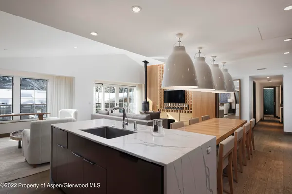 a dining hall with stainless steel appliances kitchen island a chandelier