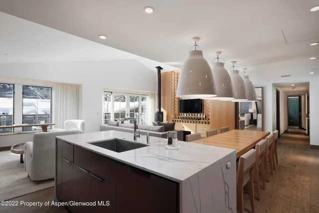 a dining hall with stainless steel appliances kitchen island a chandelier