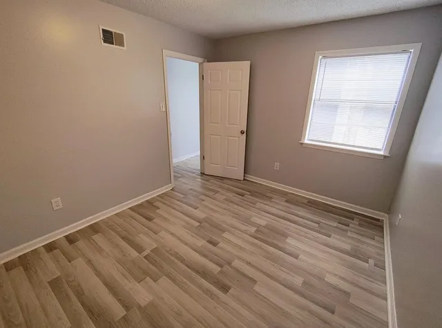 a view of room with window and hardwood floor