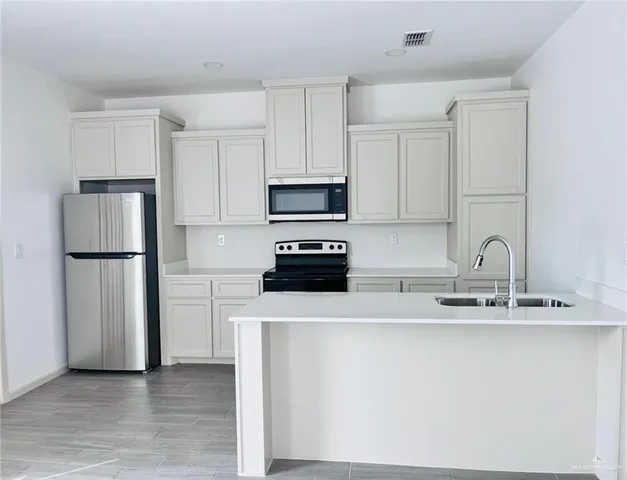 a kitchen with a refrigerator a sink and a stove