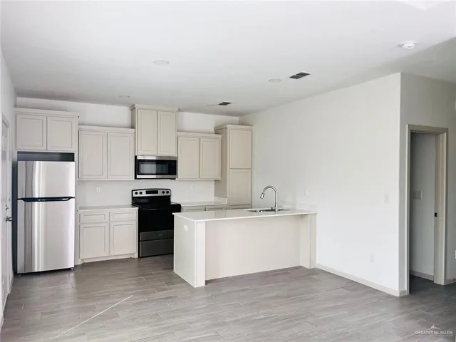 a kitchen with stainless steel appliances a refrigerator and a stove top oven