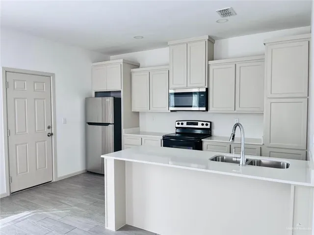 a kitchen with appliances a sink and a counter top space