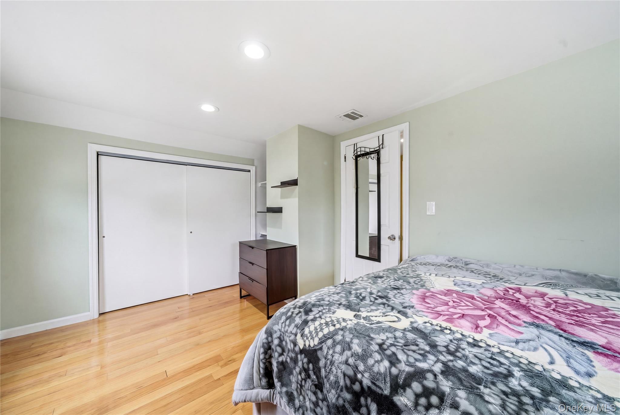 50 Ridge Lane Levittown, NY 11756 - Photo 20 of 27 a bedroom with a bed and a dresser