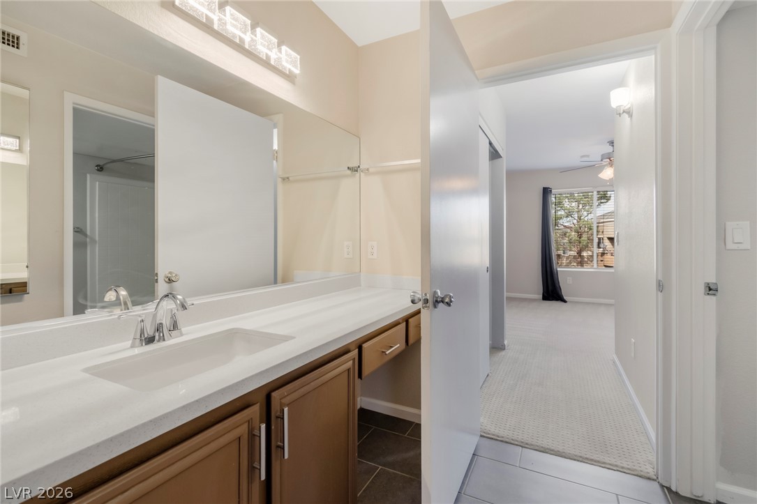 8070 West Russell Road, Unit 2006 Las Vegas, NV 89113 - Photo 18 of 24 A pristine vanity with ample counter space leads to an inviting, naturally illuminated bedroom.