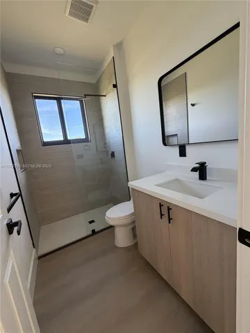 a bathroom with a double vanity sink toilet mirror and window