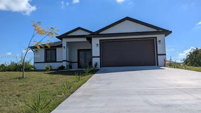 a front view of a house with a garden and yard