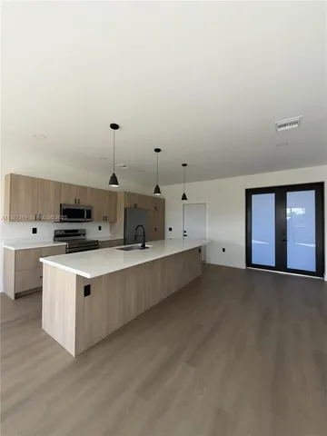 a kitchen with stainless steel appliances a stove top oven and white cabinets
