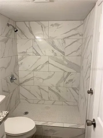 a bathroom with a toilet and a shower