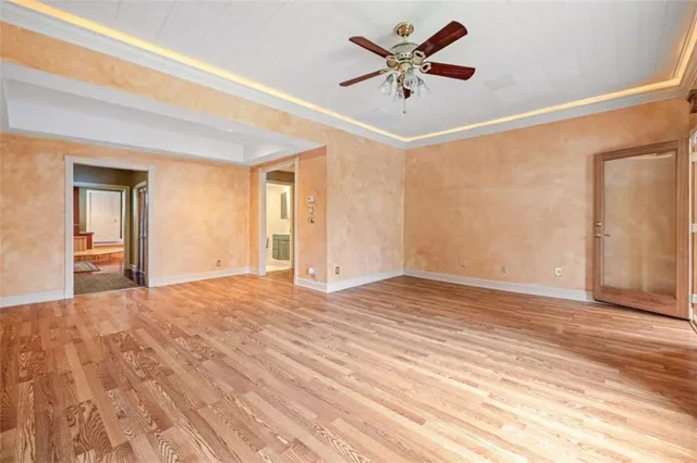 a view of a big room with wooden floor and a chandelier fan