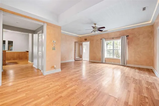 a view of an empty room with window and wooden floor