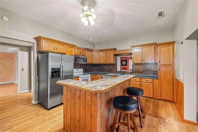 a kitchen with stainless steel appliances granite countertop a stove oven and a refrigerator with cabinets