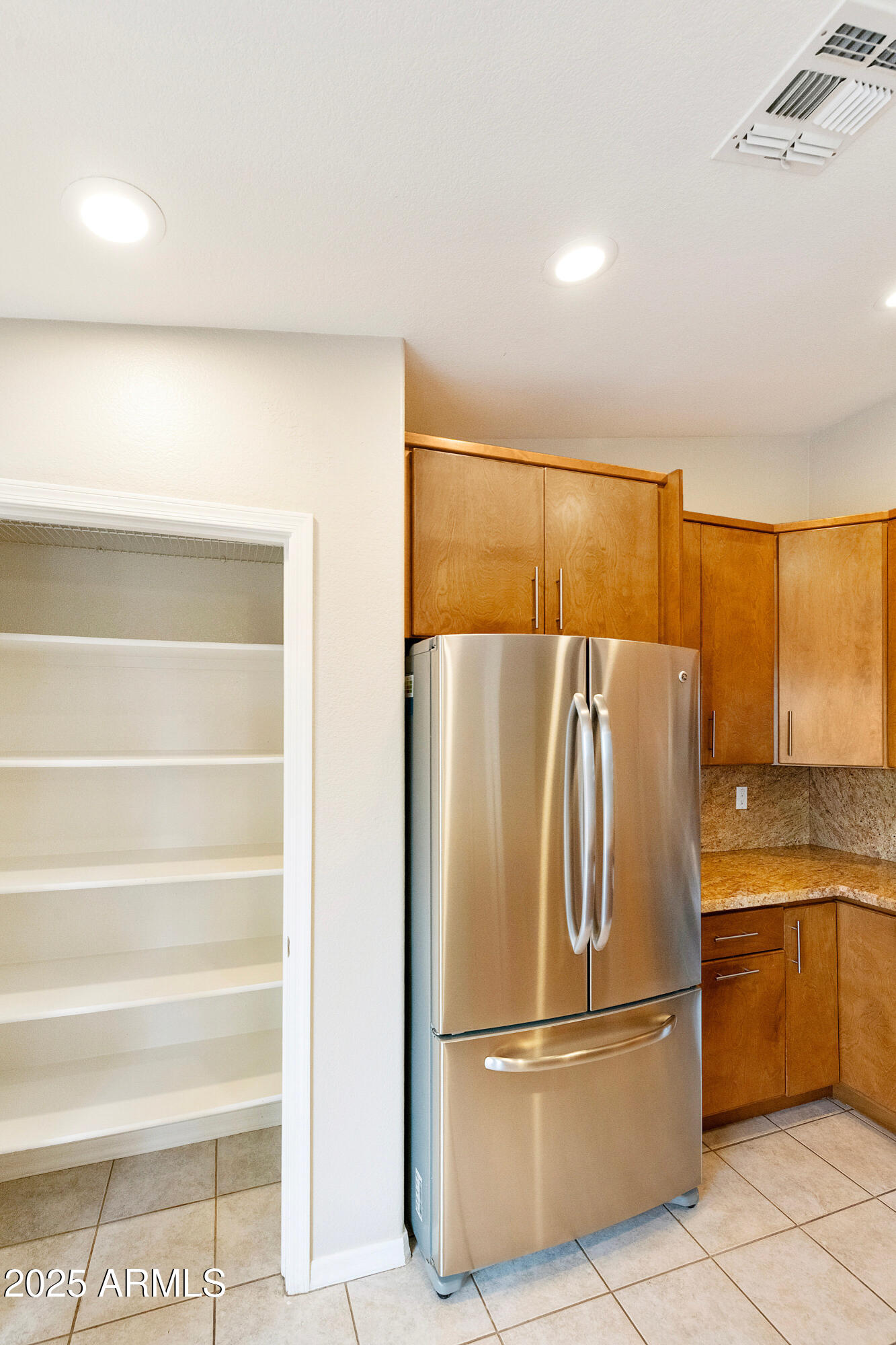 4300 East Cassia Lane Gilbert, AZ 85298 - Photo 12 of 54 a metallic refrigerator freezer sitting in a kitchen