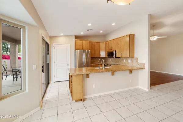 a kitchen with white cabinets and refrigerator
