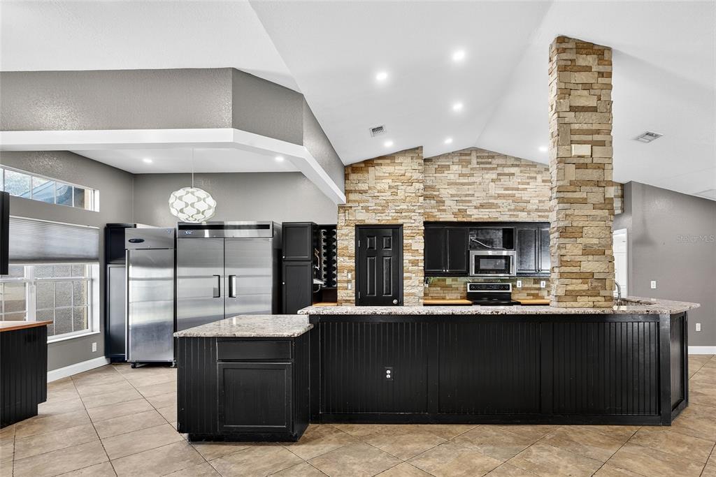 5637 Rhapsody Avenue North Port, FL 34288 - Photo 5 of 34 a kitchen with stainless steel appliances kitchen island granite countertop a large counter top and stove