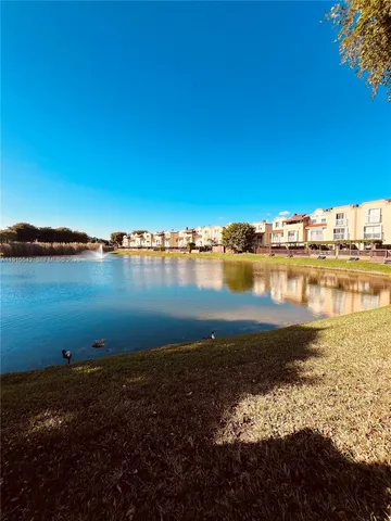 a view of a ocean with boats and trees in the background