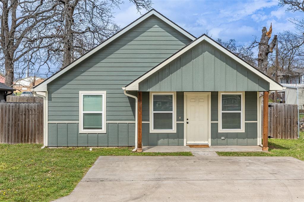 933 Rice Street Denison, TX 75020 - Photo 1 of 21 a front view of a house with a garden and yard