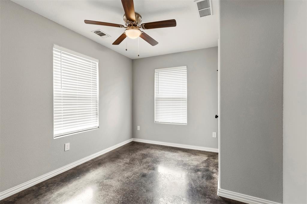 933 Rice Street Denison, TX 75020 - Photo 14 of 21 an empty room with wooden floor ceiling fan and windows
