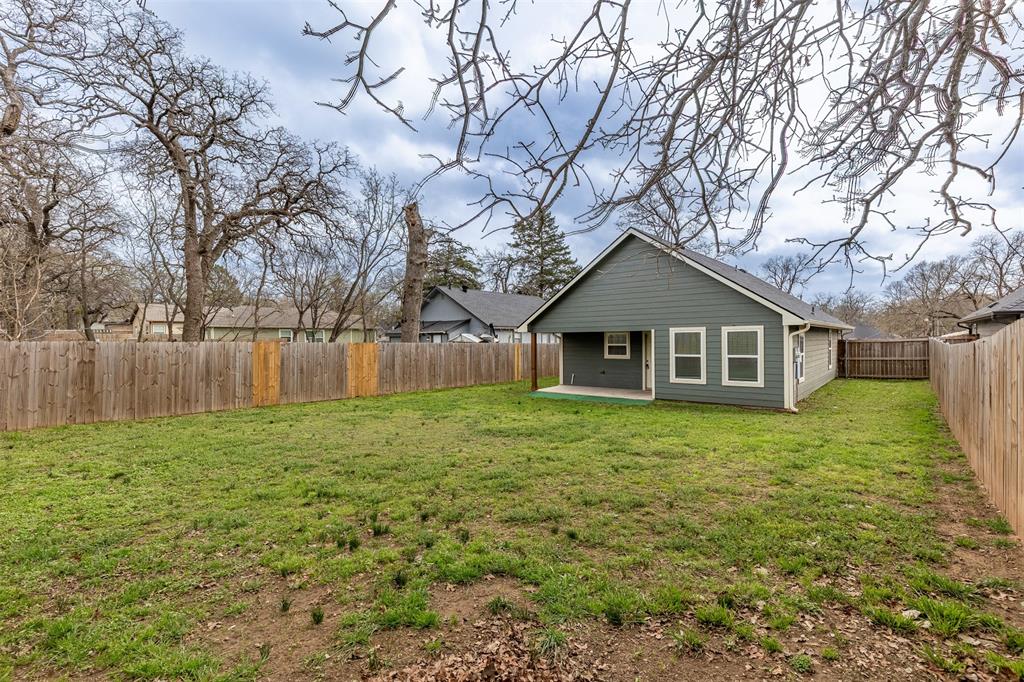 933 Rice Street Denison, TX 75020 - Photo 18 of 21 a yellow house in middle of a garden