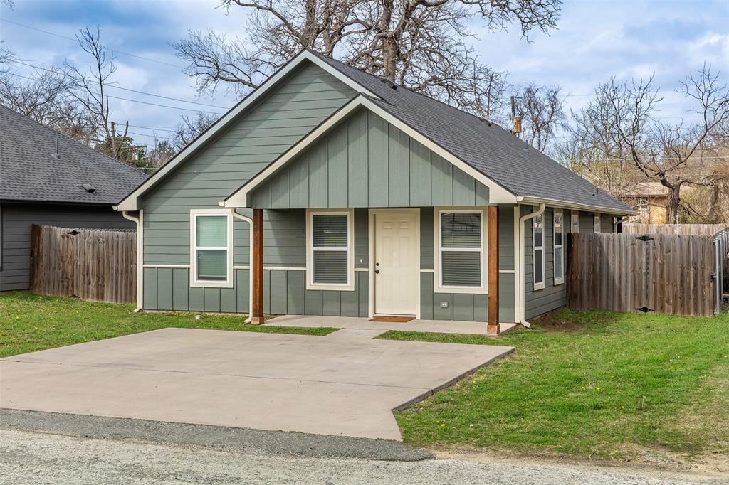 933 Rice Street Denison, TX 75020 - Photo 2 of 21 a front view of a house with a yard and garage