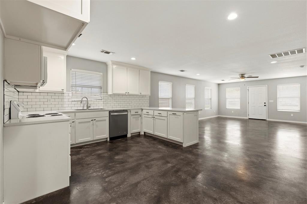 933 Rice Street Denison, TX 75020 - Photo 5 of 21 a large white kitchen with lots of counter space a sink appliances and cabinets
