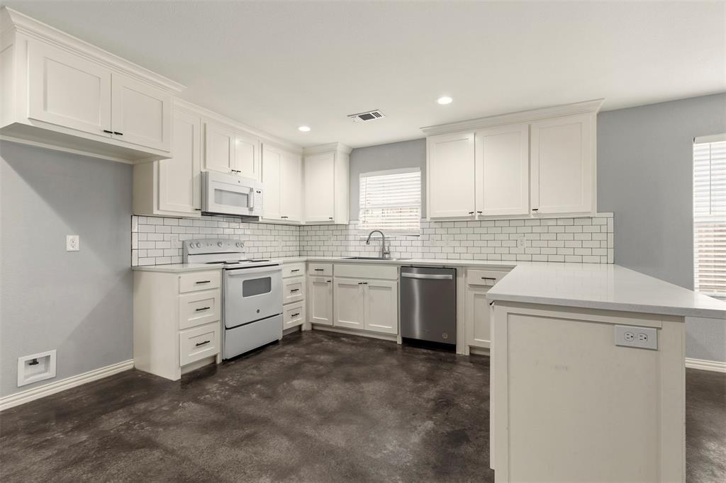 933 Rice Street Denison, TX 75020 - Photo 6 of 21 a kitchen with white cabinets white stainless steel appliances and sink