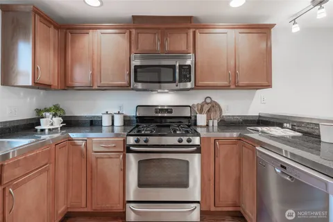a kitchen with cabinets stainless steel appliances a sink and a counter space