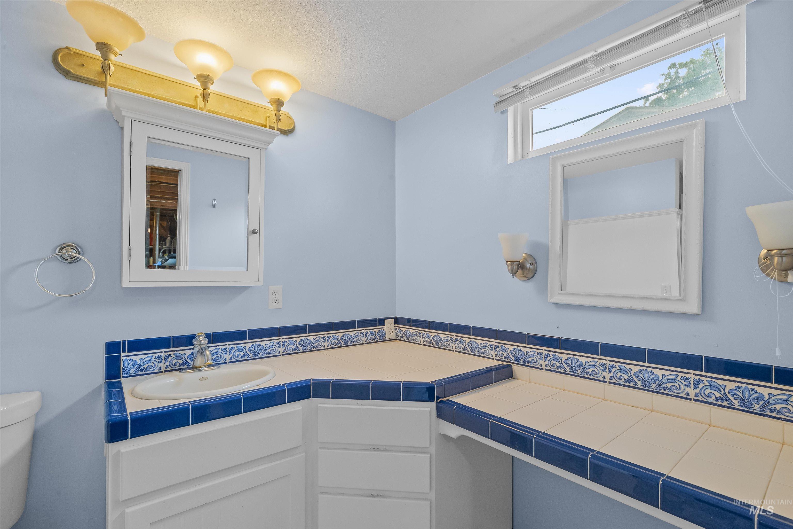 3620 18th Street Lewiston, ID 83501 - Photo 21 of 32 Bathroom featuring a corner vanity with a drop-in sink, blue and white tile countertops, and integrated cabinetry