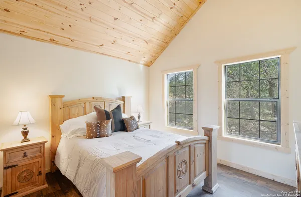 a living room with furniture floor to ceiling window hardwood floor and a flat screen tv