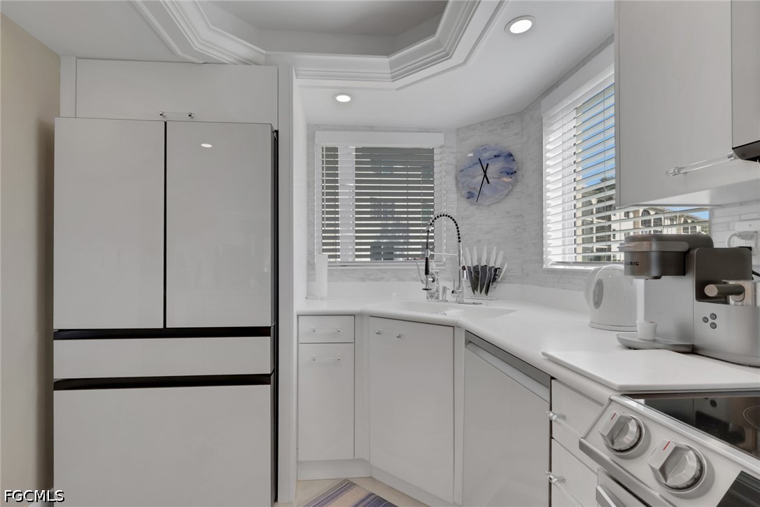 9 High Point Circle North, Unit 101 Naples, FL 34103 - Photo 15 of 49 a kitchen with stainless steel appliances a refrigerator and a sink
