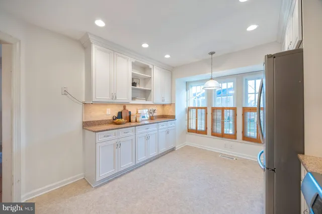 a large kitchen with stainless steel appliances a large counter top a stove and a refrigerator