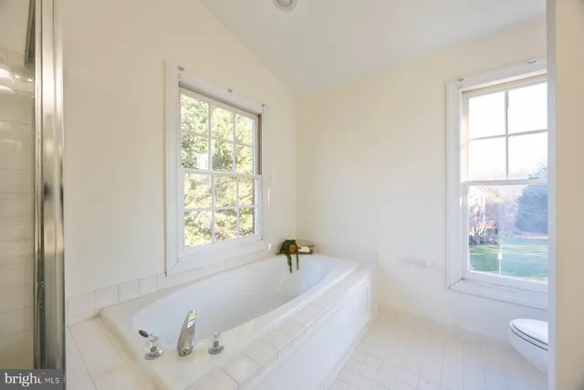 a white bath tub sitting in a bathroom next to a window
