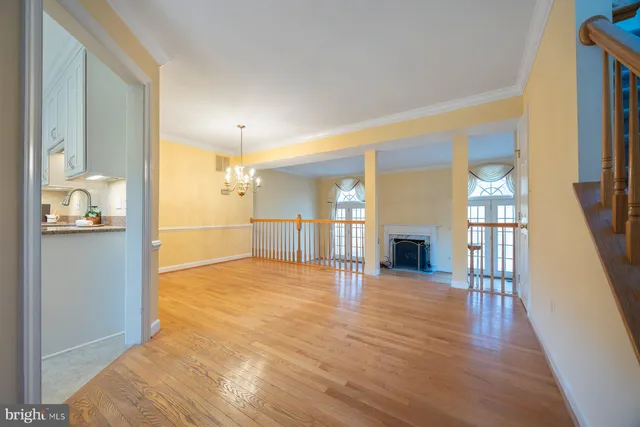 a view of a hallway with wooden floor and a kitchen