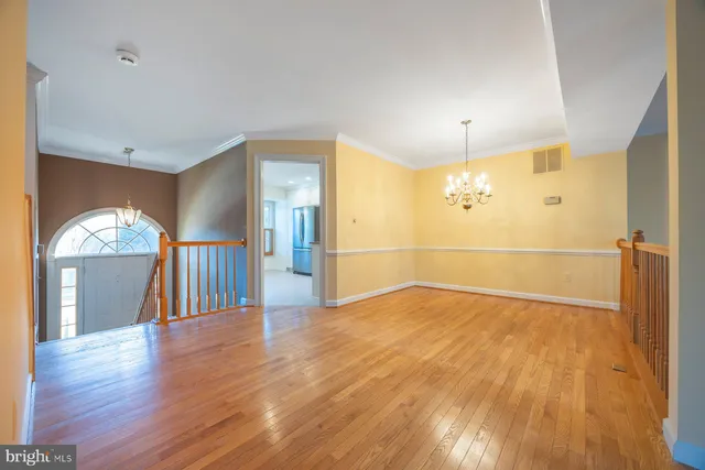 a view of empty room with wooden floor and window