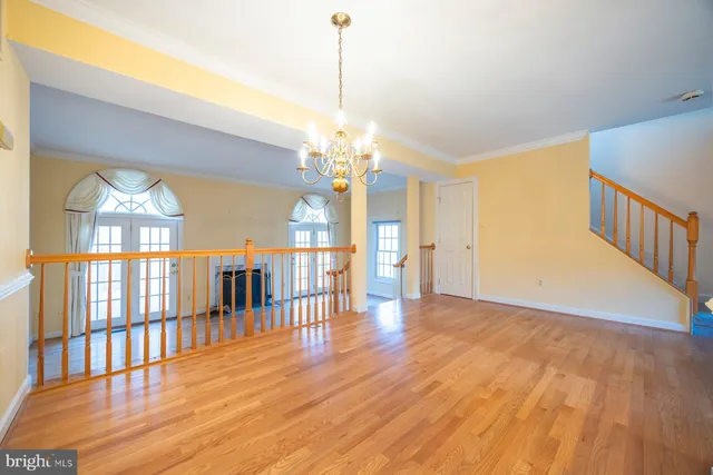 a view of a room with wooden floor fan and windows