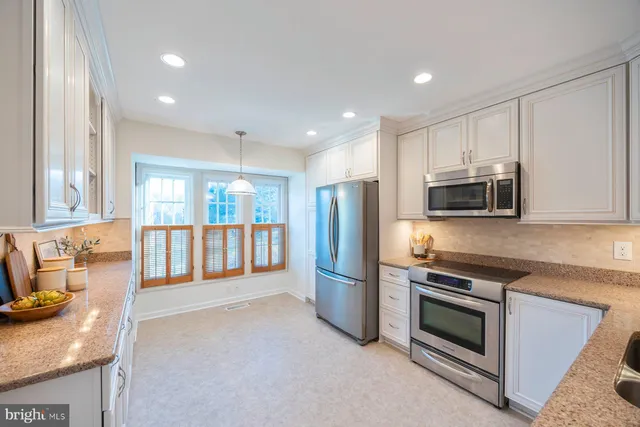 a kitchen with stainless steel appliances granite countertop a refrigerator stove and microwave