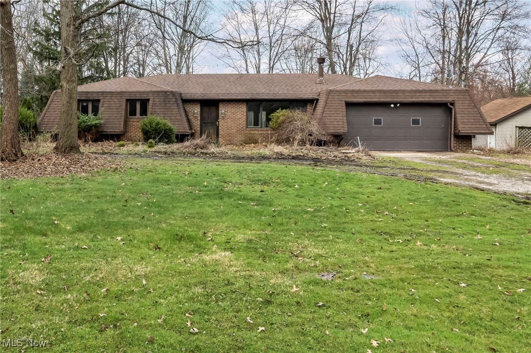 2680 Orchard Ext Road Wickliffe, OH 44092 - Photo 1 of 30 View of front of property with roof with shingles, dirt driveway, brick siding, a garage, and a front lawn