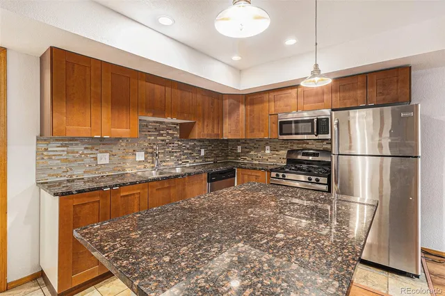 a kitchen with stainless steel appliances granite countertop a refrigerator sink and cabinets