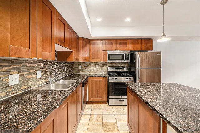 a kitchen with stainless steel appliances granite countertop a sink stove and refrigerator