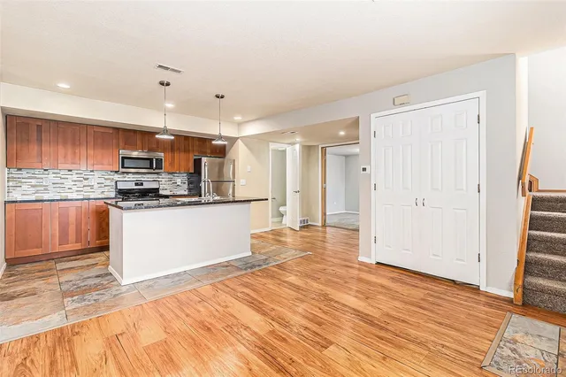 a kitchen with stainless steel appliances a refrigerator and a stove top oven