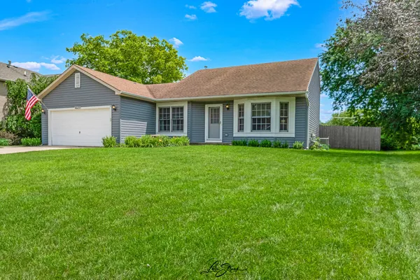 a view of a house with a yard and potted plants