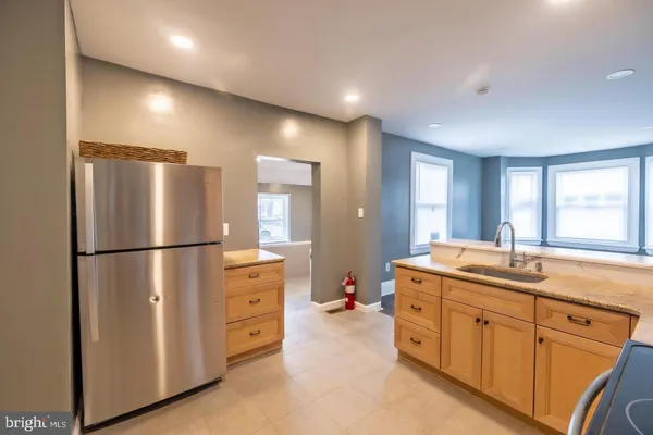 a kitchen with white cabinets and refrigerator