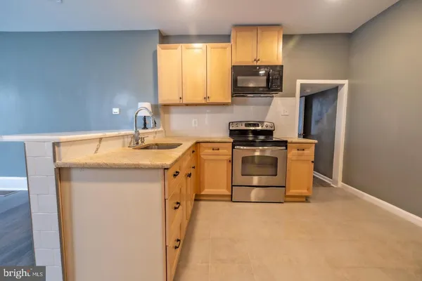 a kitchen with a sink a stove and a refrigerator