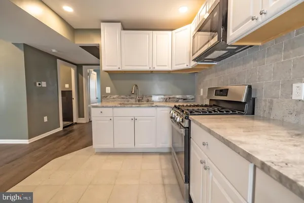 a kitchen with stainless steel appliances granite countertop a sink stove and cabinets