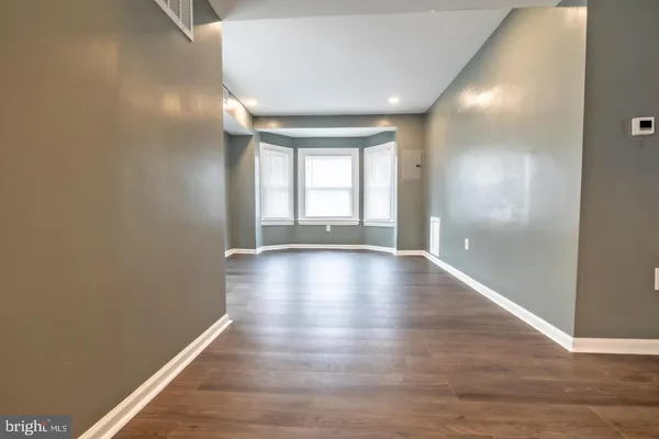 a view of room with window and wooden floor