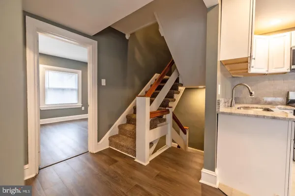 a view of a hallway with wooden floor and staircase