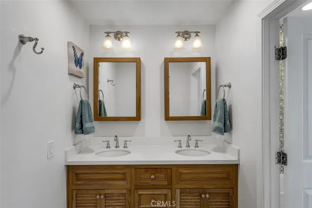 a bathroom with double sink and a mirror