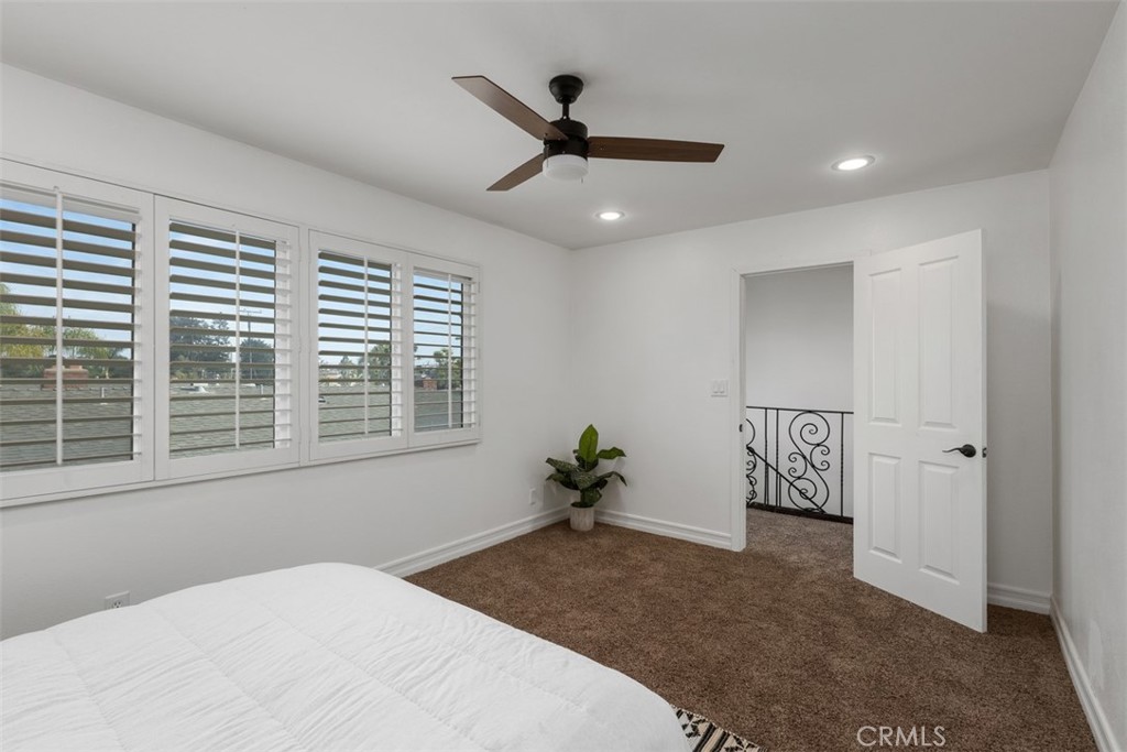 1741 Tustin Avenue, Unit 17C Costa Mesa, CA 92627 - Photo 23 of 36 a bedroom with a bed and a chandelier