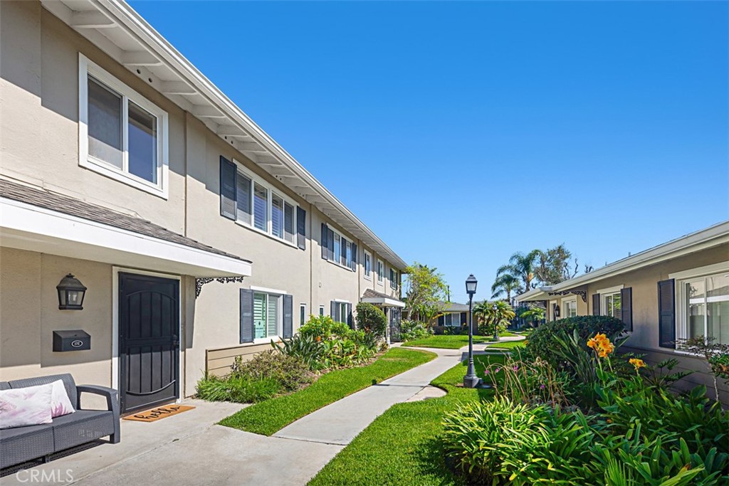 1741 Tustin Avenue, Unit 17C Costa Mesa, CA 92627 - Photo 30 of 36 a front view of a house with a yard and potted plants