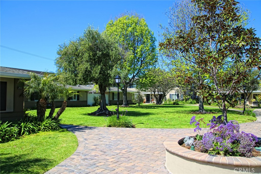 1741 Tustin Avenue, Unit 17C Costa Mesa, CA 92627 - Photo 33 of 36 a view of a garden with plants and large trees