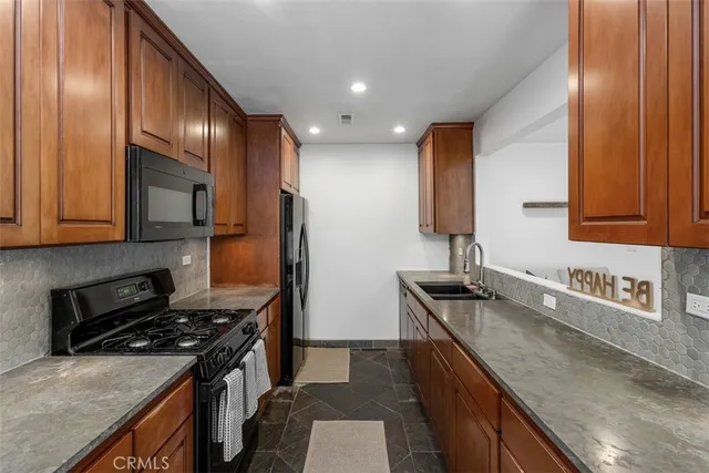a kitchen with granite countertop stainless steel appliances and wooden cabinets